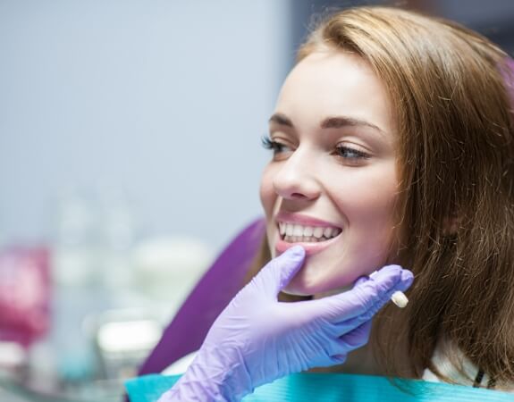 Dentist examining dental patient's smile after onlay treatment