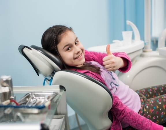 Child giving thumbs up during their first visit