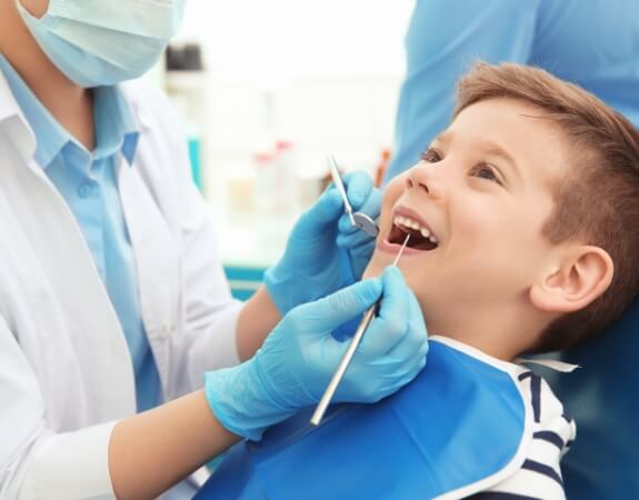 Child receiving dental checkup and teeth cleaning