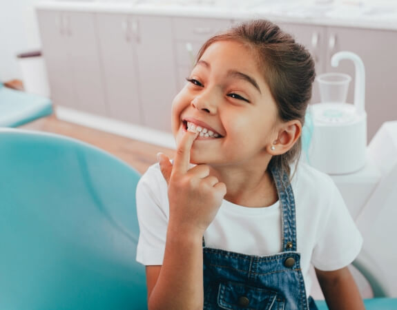 Child pointing to smile after tooth colored fillings