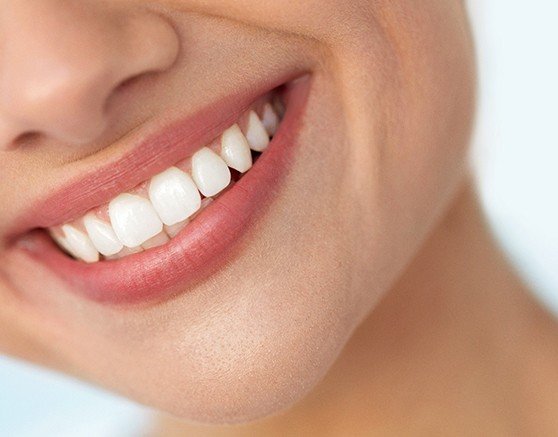 Nose-to-neck ¾ profile view of woman smiling