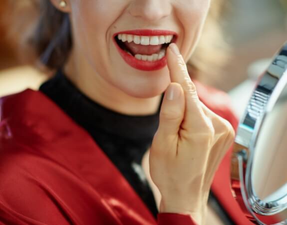 Patient pointing to smile after cosmetic dental bonding