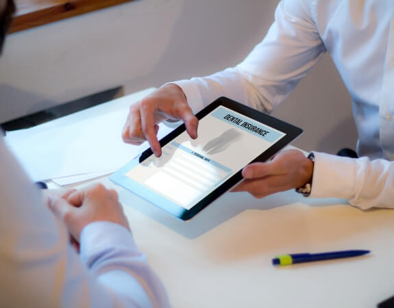 Dentist and patient reviewing dental insurance forms