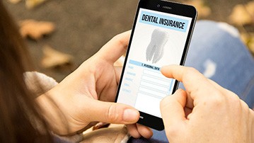 Woman looking at dental insurance information on phone