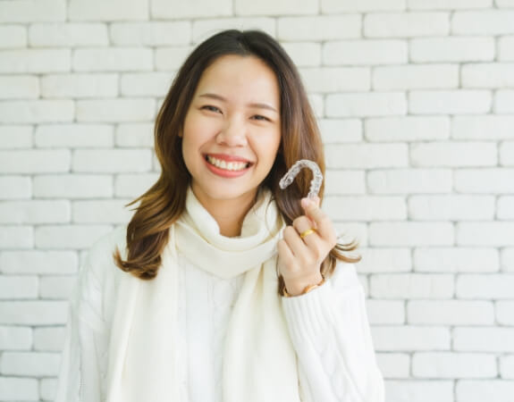 Smiling woman enjoying the benefits of Invisalign