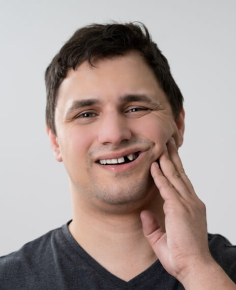 Man with gap in smile before replacing missing teeth