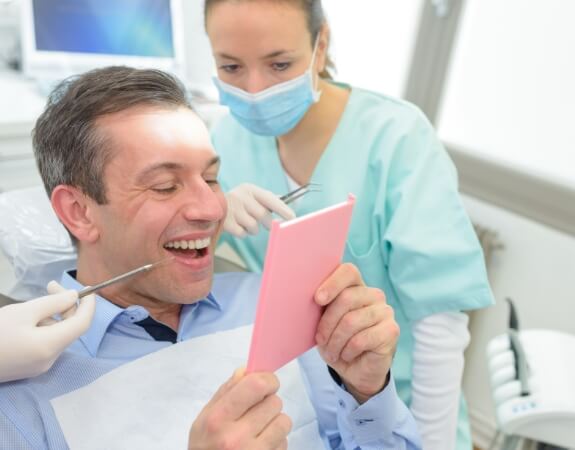 Man looking at smile before dental bridge restoration