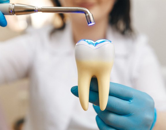 Light being shined on the model of a tooth