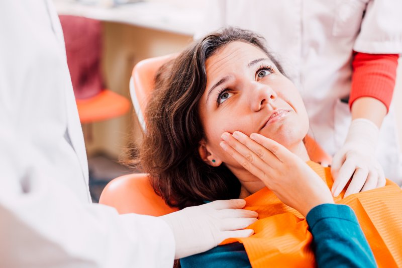 patient holding their tooth in pain